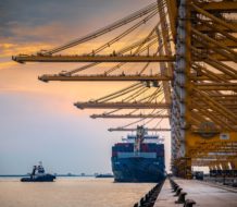 Container ships docked at Jebel Ali port, Dubai, with cranes overhead