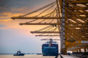 Container ships docked at Jebel Ali port, Dubai, with cranes overhead